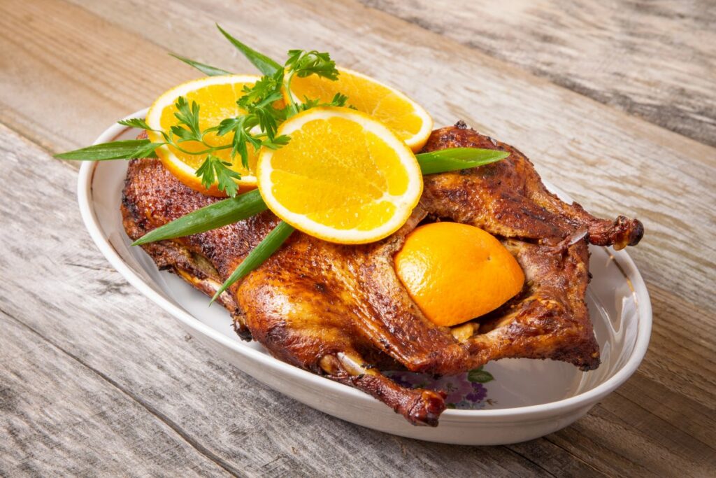 Roasted duck with orange slices.