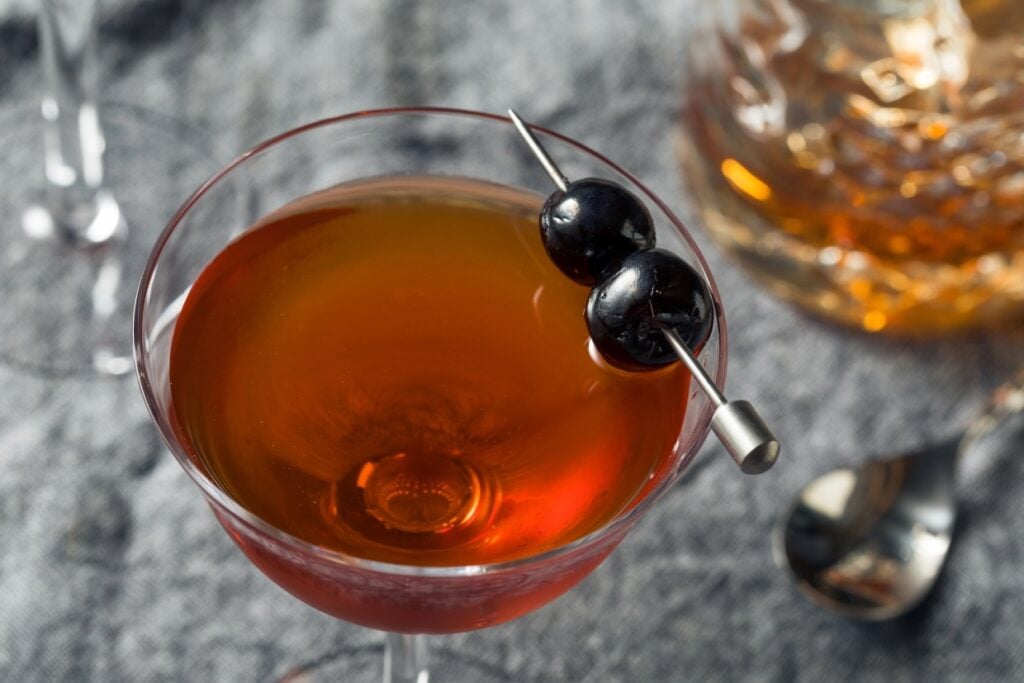 Rob Roy in a cocktail glass with skewered cherries.