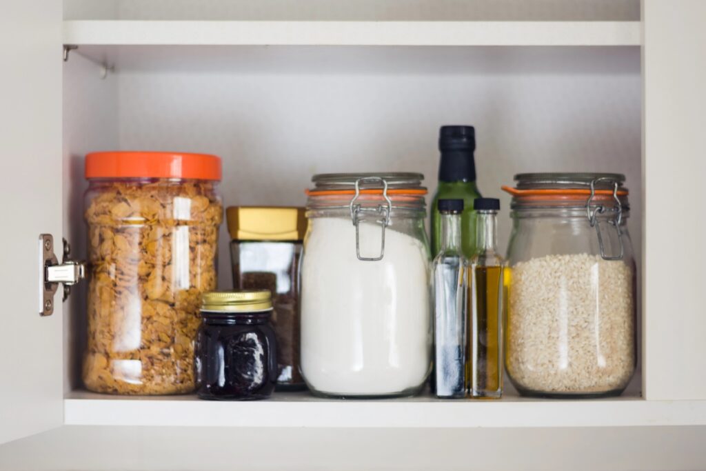 Items in containers in a small pantry.