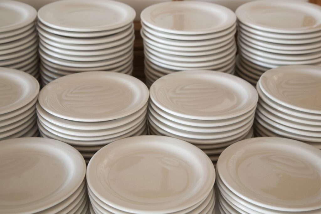 Stacks of clean white plates neatly arranged on a countertop.