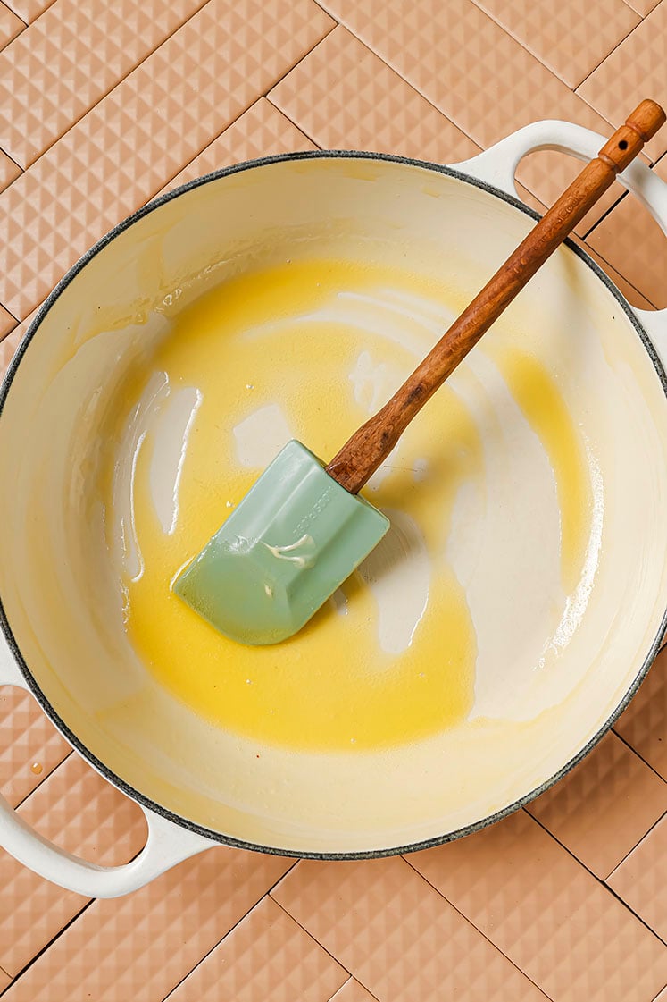 Melted butter in a skillet with a spatula.