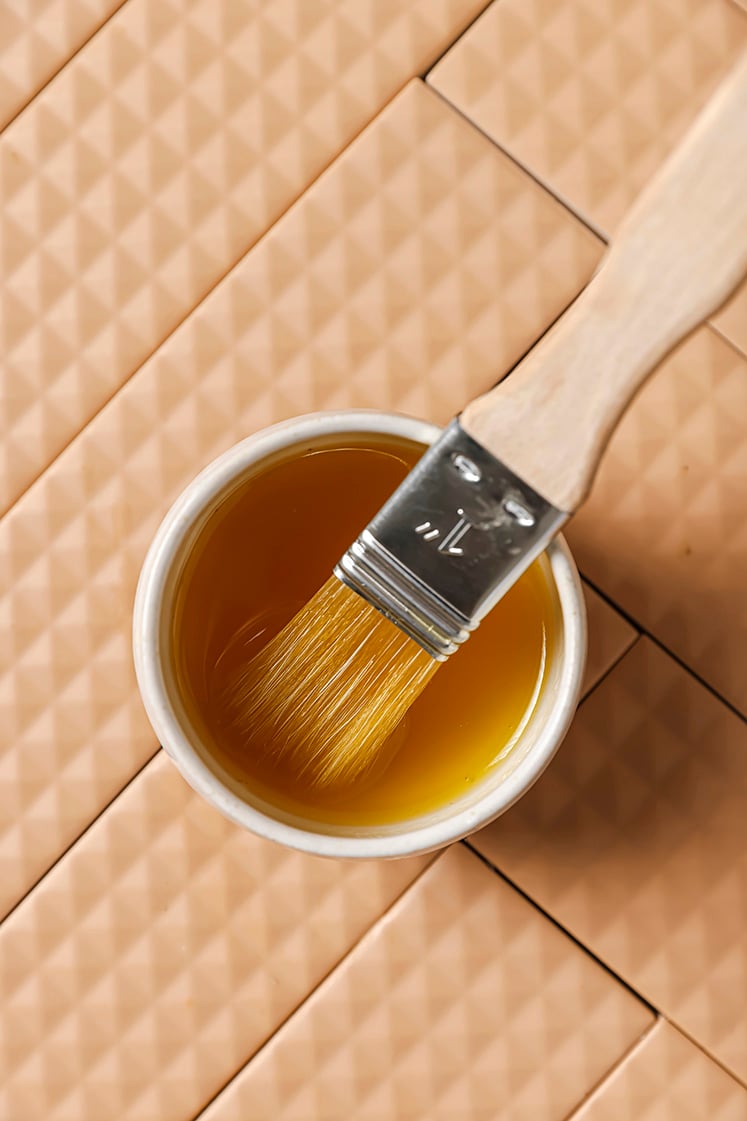 Honey in a small bowl with a brush.