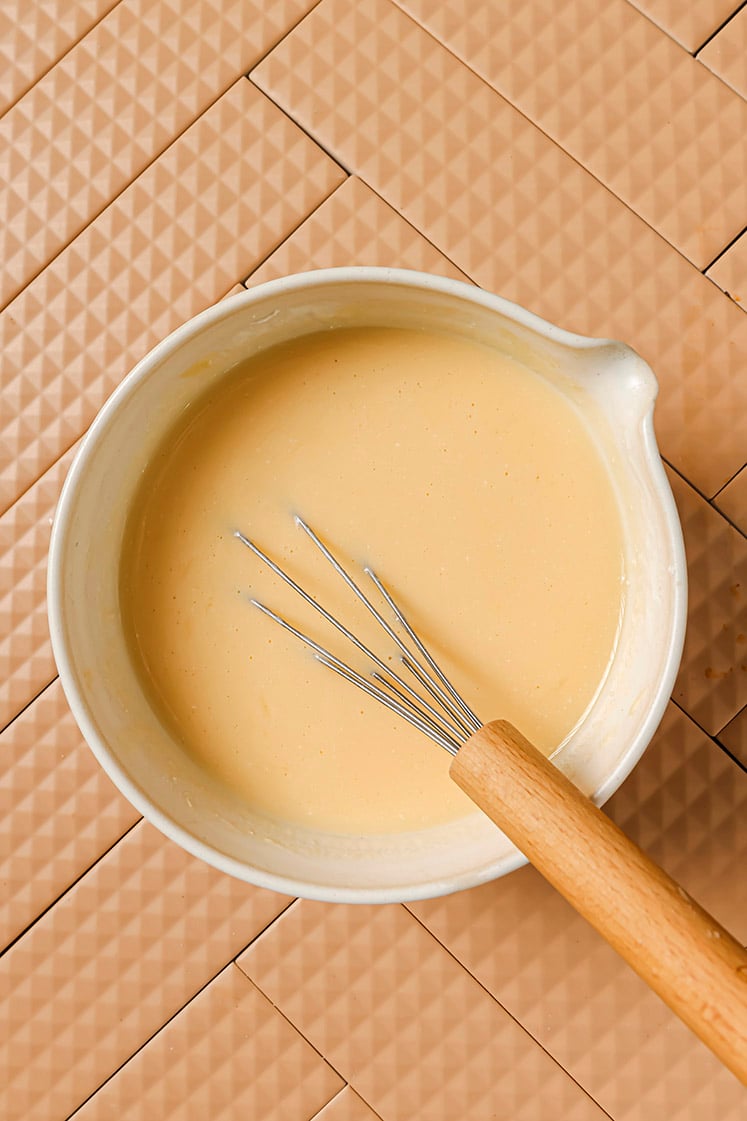 Wet ingredients in a mixing bowl with a whisk.