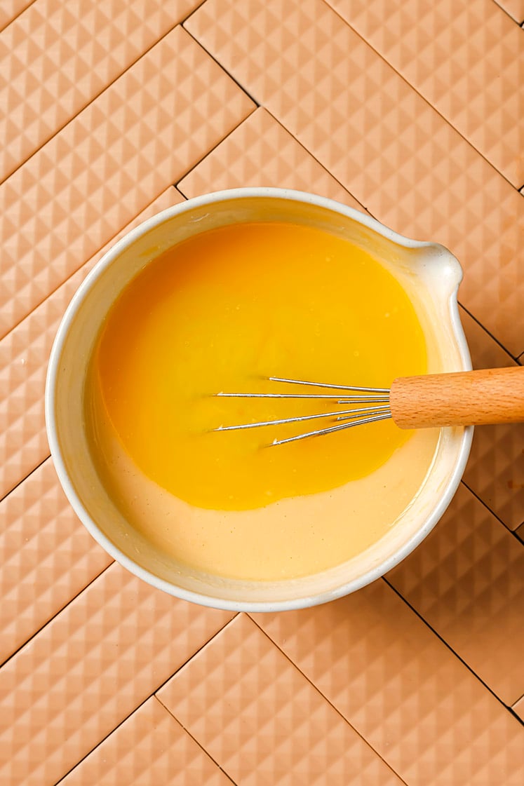 Wet ingredients in a mixing bowl with a whisk.