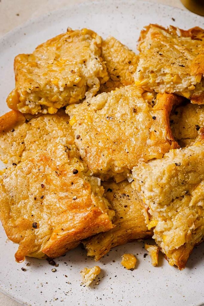 A plate of Jiffy corn casserole slices, seasoned with black pepper.