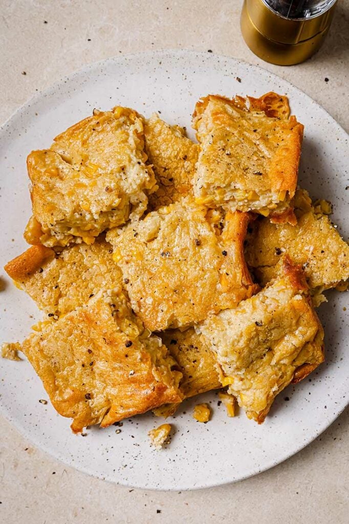 A plate of Jiffy corn casserole slices, seasoned with black pepper.