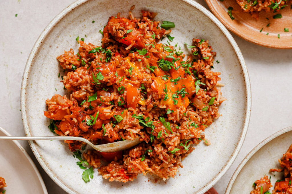 Stuffed bell pepper casserole garnished with fresh herbs on a plate.