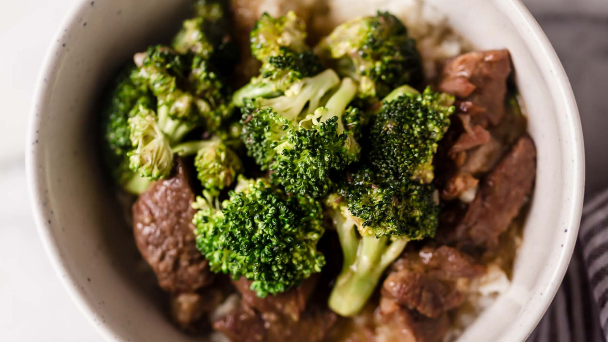 Bowl of Instant Pot beef and broccoli served over white rice, with tender beef pieces and bright green broccoli florets.