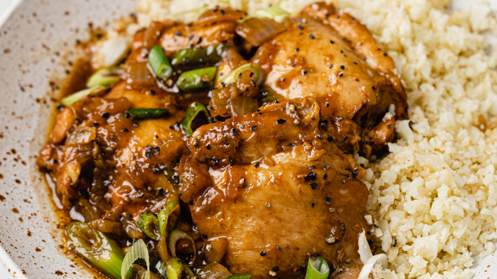 Instant Pot chicken adobo with cauliflower rice on a plate.
