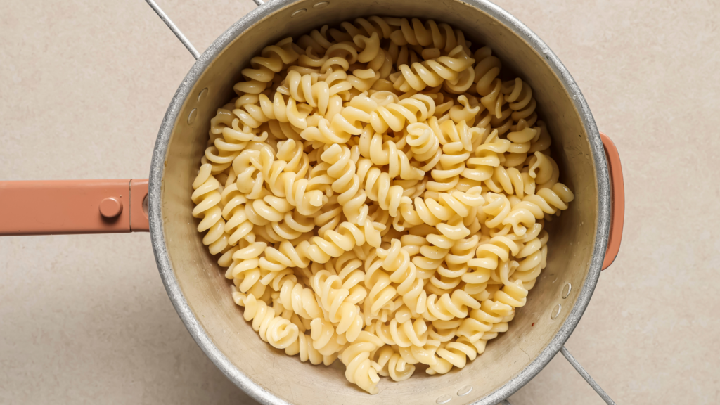 Overhead shot of freshly cooked fusilli pasta in a pot, fully drained, rinsed and ready for sauce or serving.