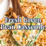 A wooden spoon scoops creamy green bean casserole topped with crispy fried onions from a white baking dish. The text "Fresh Green Bean Casserole" overlays the image.
