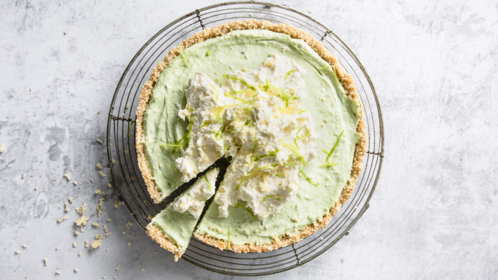 Creamy key lime pie topped with whipped cream and lime zest, with a graham cracker crust.