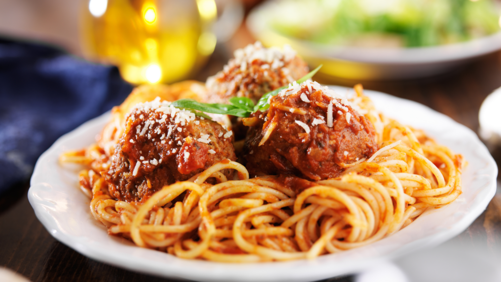 Spaghetti noodles topped with marinara sauce, large meatballs, and shredded Parmesan.