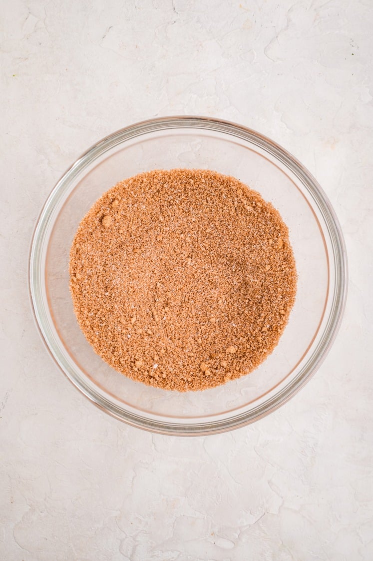 A glass bowl filled with a well-mixed cinnamon-sugar blend, showing a fine, even mixture of brown sugar, granulated sugar, and ground cinnamon.