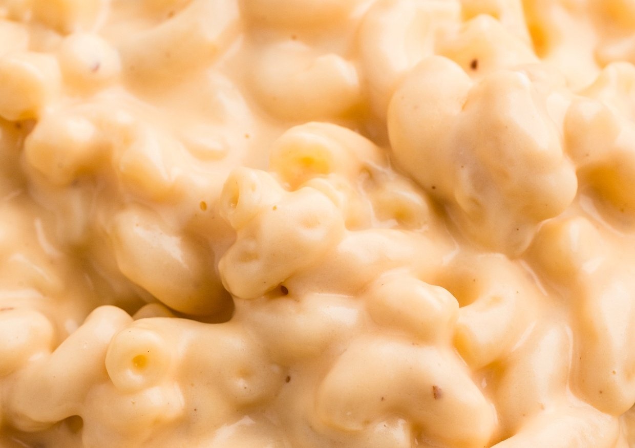 Close-up of creamy macaroni and cheese, showing elbow pasta coated in melted cheese sauce.