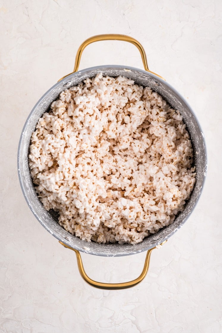 Rice Krispie treat mixture stirred together in a pot with melted marshmallow and butter.