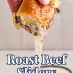 Close-up of a hand lifting a roast beef slider with melted cheese stretching down from the sandwich, topped with seasoning, with the text 'Roast Beef Sliders' - Real Balanced , overlaid at the bottom.