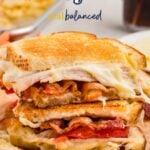 A turkey melt sandwich cut in half, stacked on brown parchment paper, with melted cheese, turkey, and crispy bacon visible. The text "Turkey Melt" and "real balanced" appears above the sandwich.