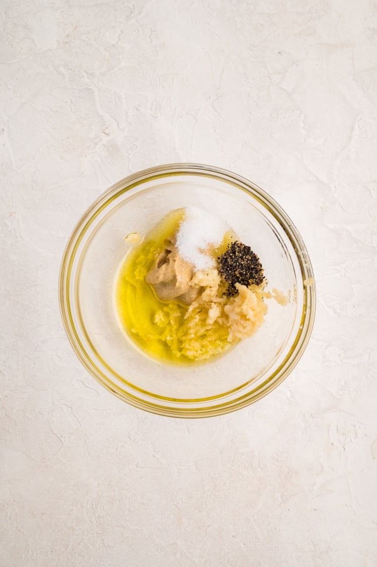 Garlic, olive oil, Dijon mustard, salt, and pepper mixed in a small bowl for seasoning pork tenderloin.