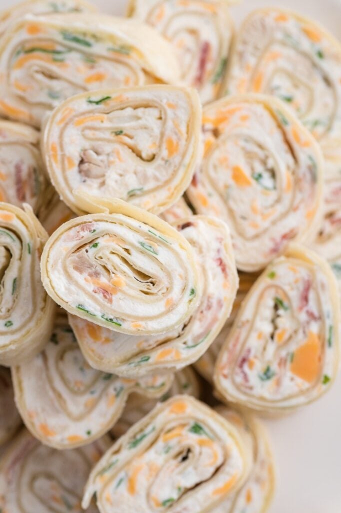 Close-up of crack chicken pinwheels made with tortillas, creamy chicken filling, cheddar, bacon, and green onions.