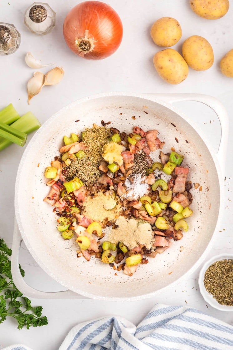 Seasoned bacon and celery in a pot.