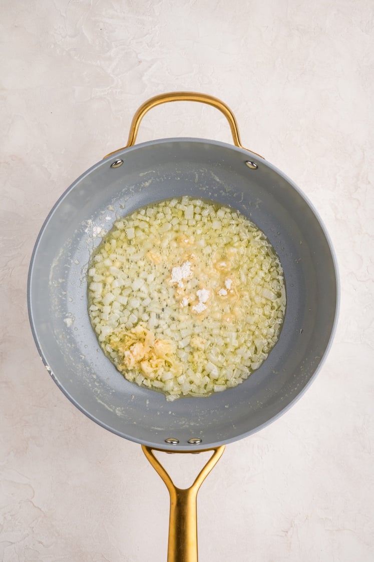 Adding garlic to onions cooking in butter.