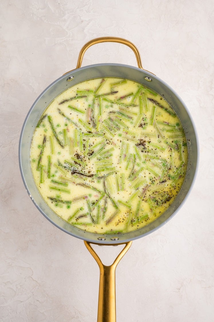 Asparagus added to the broth as it simmers in the pan.