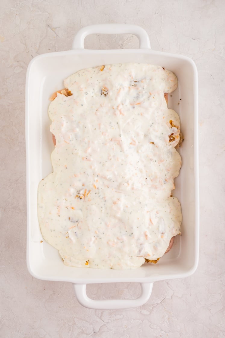 Chicken breasts in a baking dish covered with creamy onion sauce.