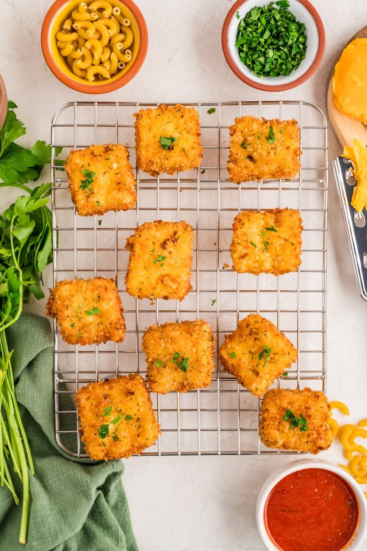 Fried mac and cheese bites cooling on a wire rack.