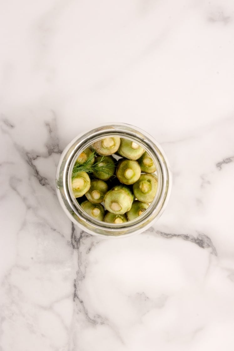Okra packed into a glass jar.