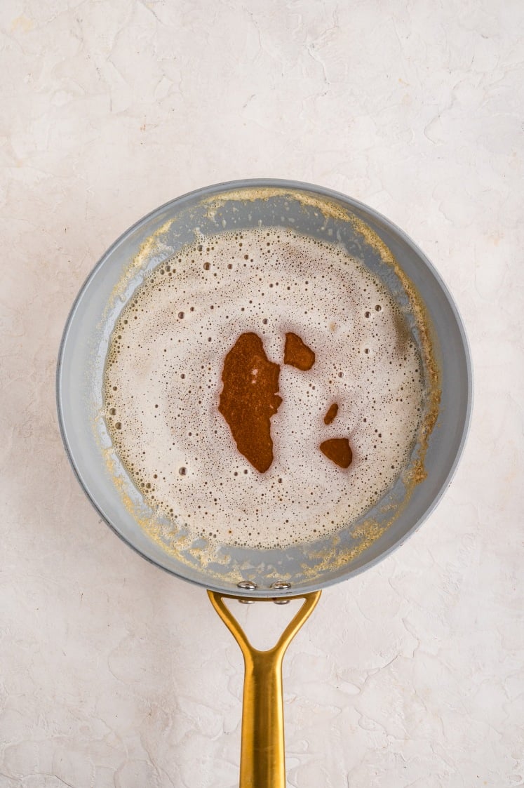 Butter beginning to foam in a skillet.
