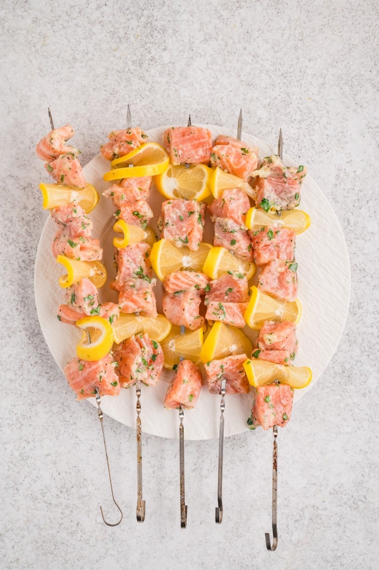 The salmon once it’s threaded onto the skewers with lemon slices.