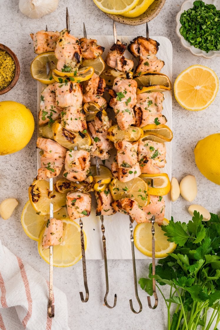 Finish with a squeeze of the grilled lemon right over the skewers and a sprinkle of fresh herbs.
