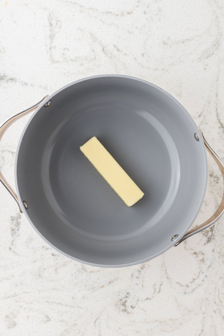 Stick of butter melting in a saucepan.