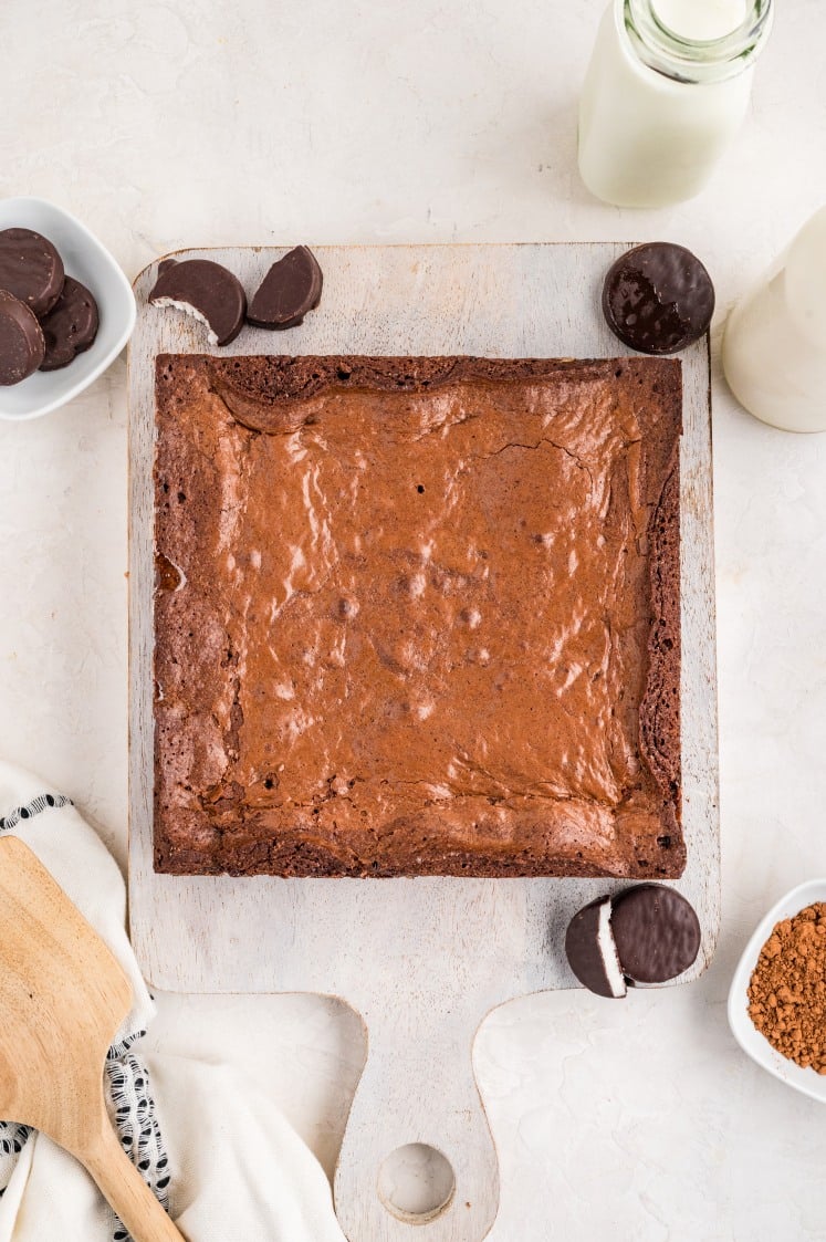 The baked brownies resting on a cutting board, cooled and ready to be sliced into rich, fudgy peppermint patty brownies.