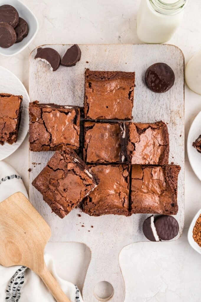Peppermint patty brownies cut into squares on a cutting board.