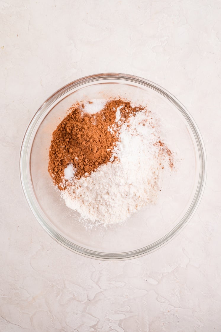 Dry ingredients (flour, cocoa powder, cornstarch, baking soda, and salt) measured into a bowl, ready to be whisked together before adding to the batter.
