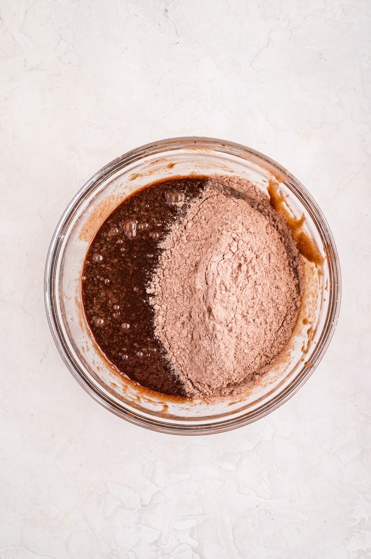 Dry ingredients added to the wet brownie mixture, ready to be gently folded together until just combined.