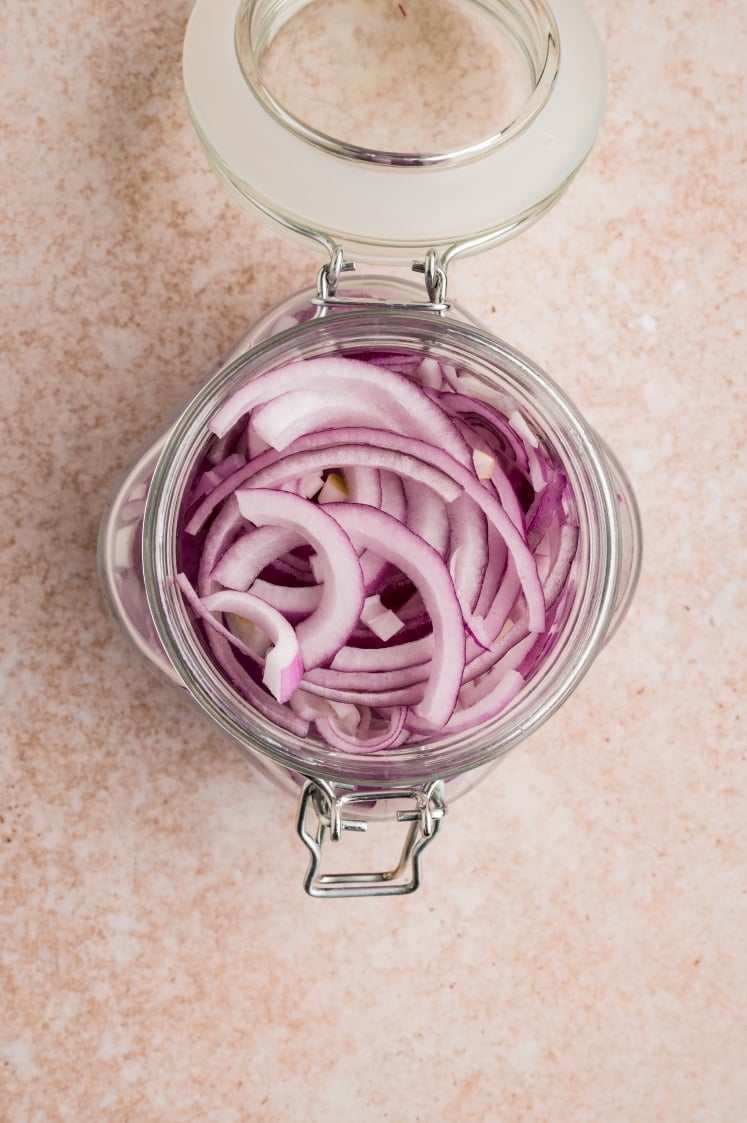 Thin-sliced red onions, ready to soak and soften.