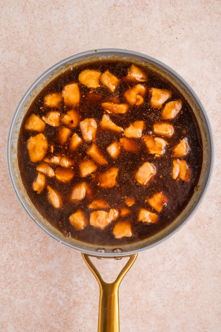 Chicken pieces coated in thickened sauce in a skillet.