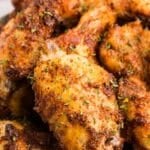 Close-up of crispy spice rubbed chicken wings with golden, seasoned skin.