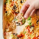 Taco dip with cream cheese topped with lettuce, tomatoes, olives and cheese