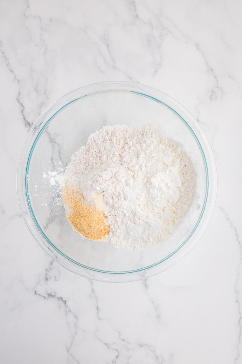 Flour, cornstarch, baking powder, salt, garlic powder, and onion powder in a glass mixing bowl.