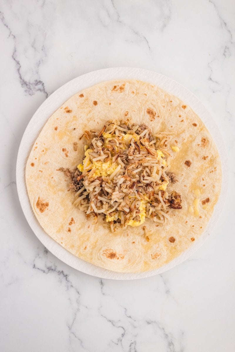 Crispy hash browns layered over the eggs and sausage on the tortilla.