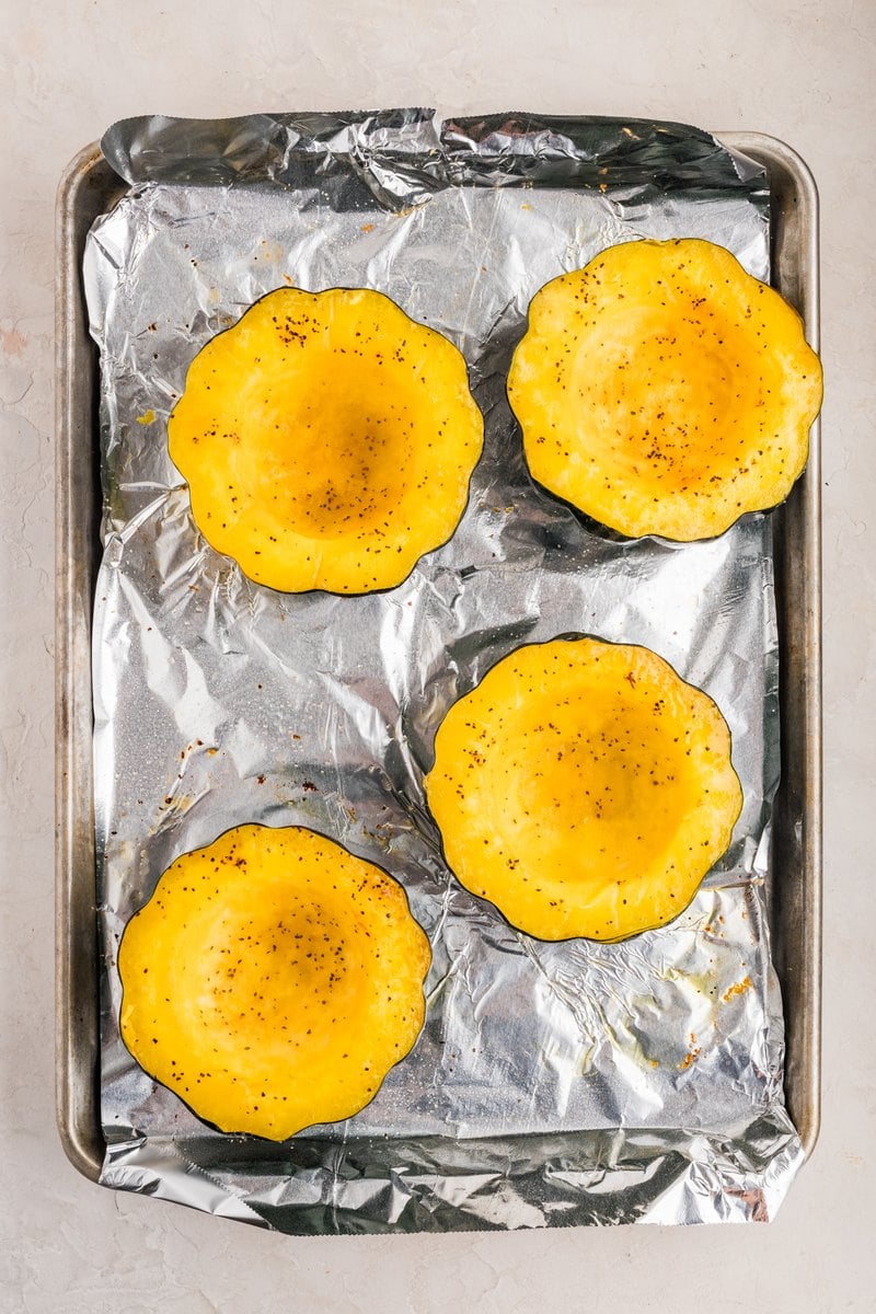 Roasted acorn squash halves turned cut side up on the baking sheet, tender and golden.