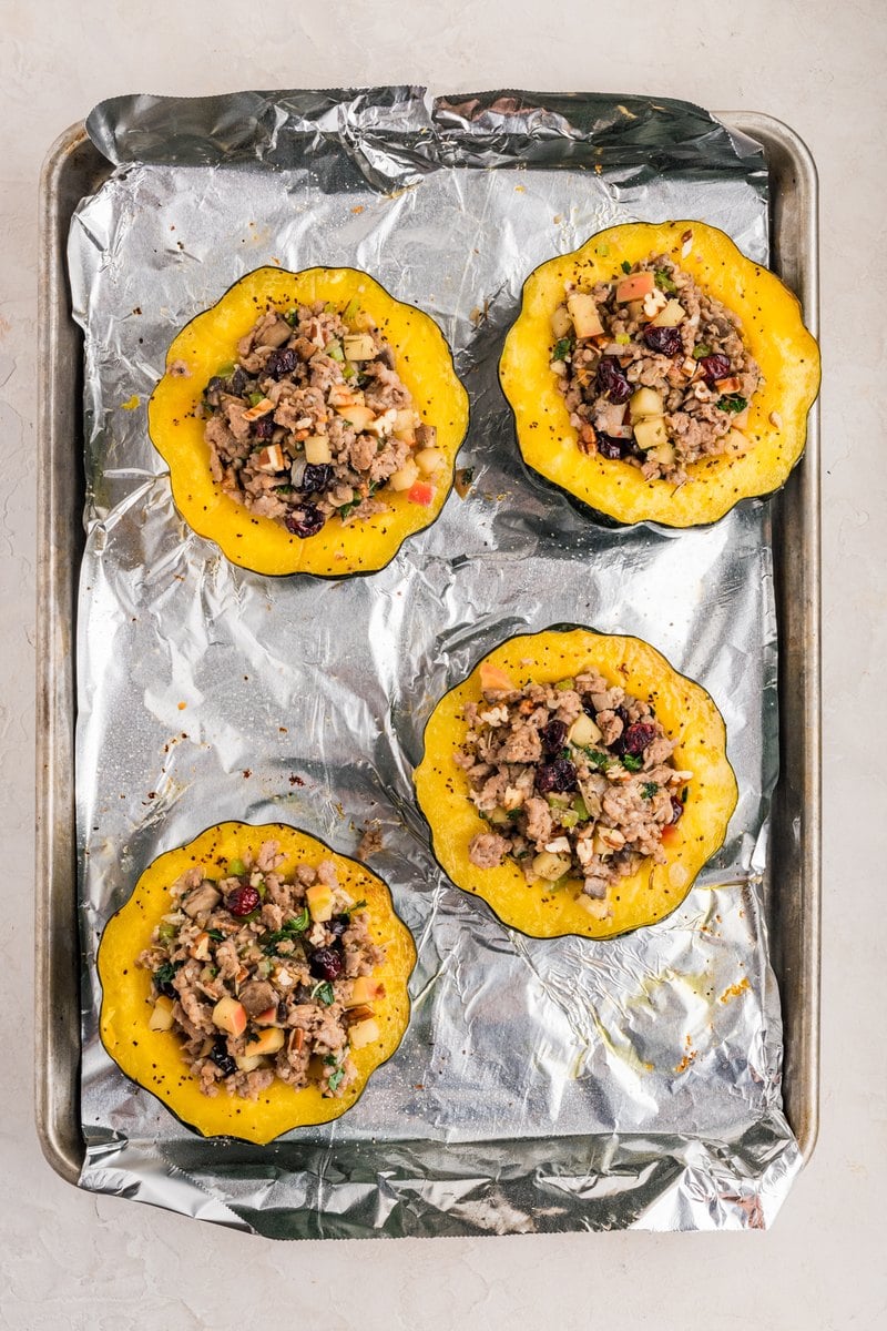 Acorn squash halves filled and mounded with the sausage, apple, and cranberry stuffing.